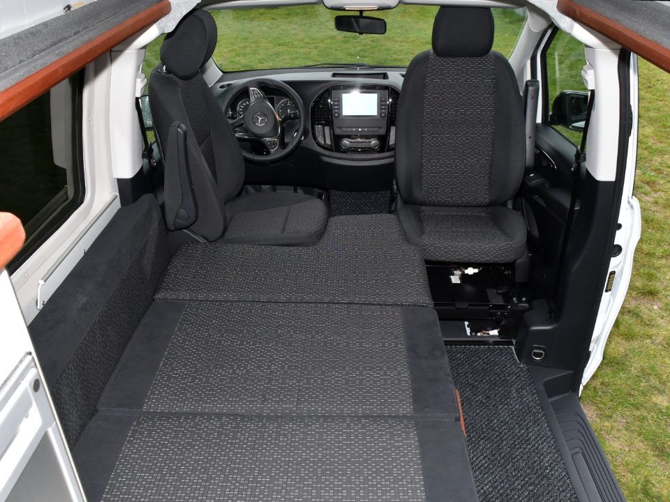 Innenansicht des Campmobils Richtung Front mit aufgebauter Liegefläche