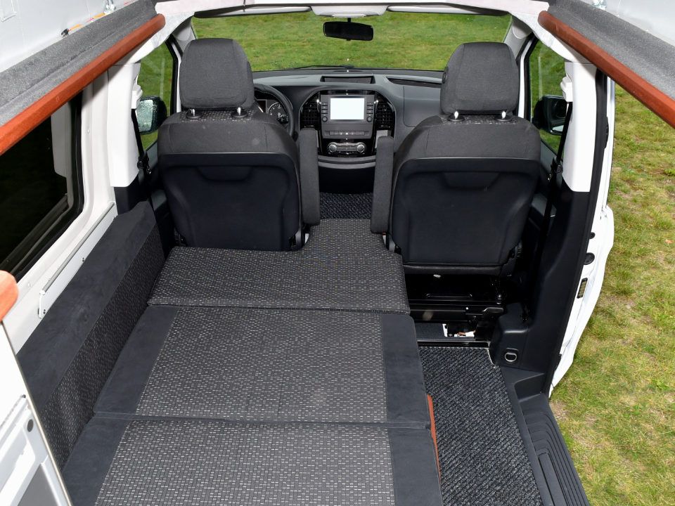 Innenansicht des Campmobils Richtung Front mit aufgebauter Liegefläche