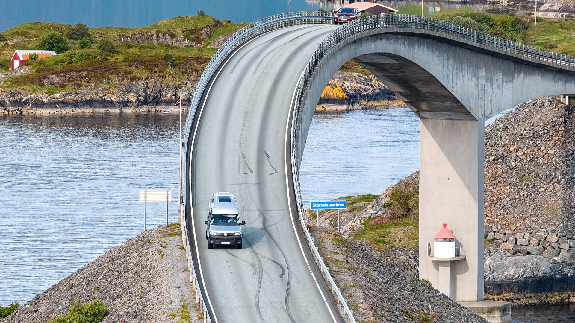 Campmobil Van fährt über eine stark gekrümmte Betonbrücke