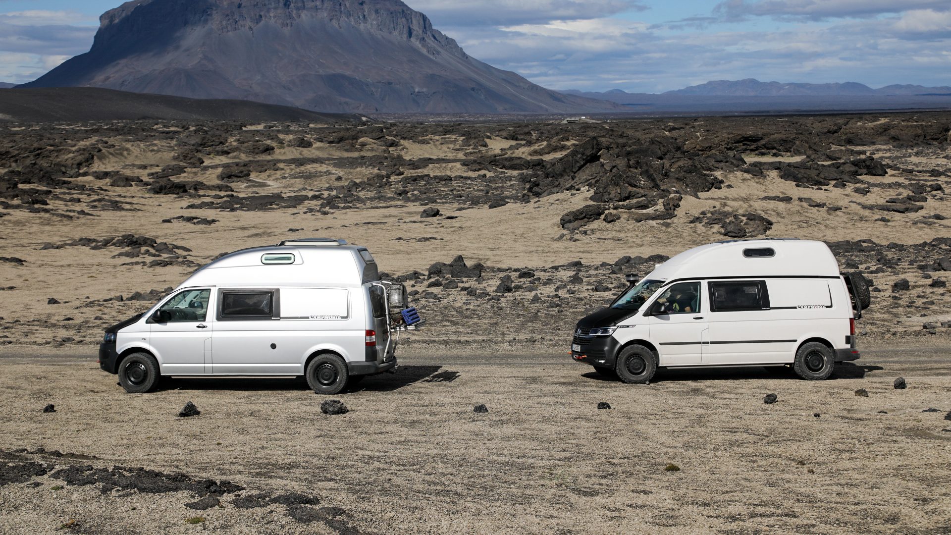 Zwei Campmobil Vans hintereinander durchgequeren eine Wüste